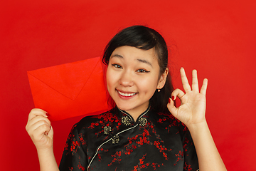 Image showing Happy Chinese new year. Asian young girls\'s portrait isolated on red background