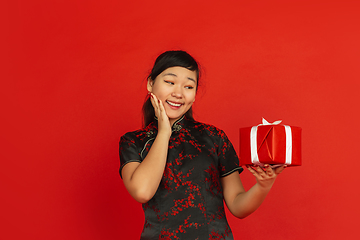 Image showing Happy Chinese new year. Asian young girls\'s portrait isolated on red background