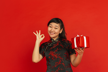 Image showing Happy Chinese new year. Asian young girls\'s portrait isolated on red background