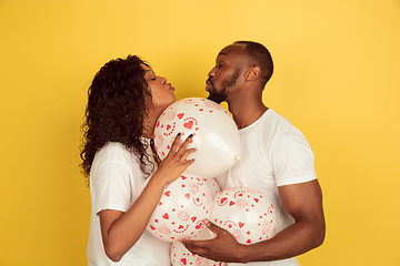 Image showing Valentine\'s day celebration, happy african-american couple isolated on yellow background