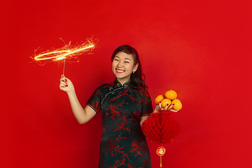 Image showing Happy Chinese New Year. Asian young girls\'s portrait isolated on red background