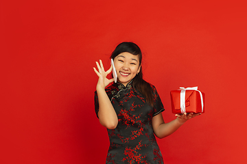 Image showing Happy Chinese New Year. Asian young girls\'s portrait isolated on red background