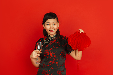 Image showing Happy Chinese New Year. Asian young girls\'s portrait isolated on red background