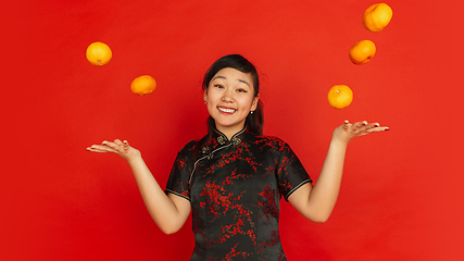 Image showing Happy Chinese New Year. Asian young girls\'s portrait isolated on red background