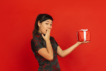 Image showing Happy Chinese New Year. Asian young girls\'s portrait isolated on red background