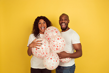 Image showing Valentine\'s day celebration, happy african-american couple isolated on yellow background