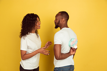 Image showing Valentine\'s day celebration, happy african-american couple isolated on yellow background