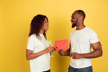 Image showing Valentine\'s day celebration, happy african-american couple isolated on yellow background