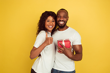 Image showing Valentine\'s day celebration, happy african-american couple isolated on yellow background