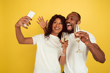 Image showing Valentine\'s day celebration, happy african-american couple isolated on yellow background