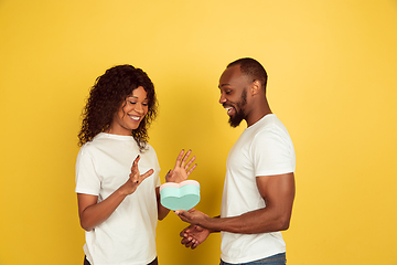 Image showing Valentine\'s day celebration, happy african-american couple isolated on yellow background