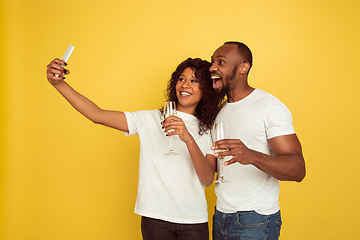 Image showing Valentine\'s day celebration, happy african-american couple isolated on yellow background