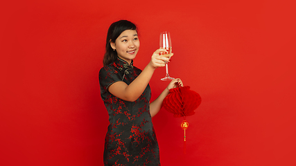 Image showing Happy Chinese New Year. Asian young girls\'s portrait isolated on red background