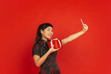 Image showing Happy Chinese New Year. Asian young girls\'s portrait isolated on red background