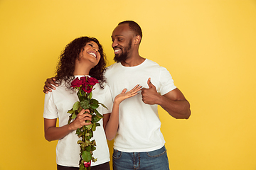 Image showing Valentine\'s day celebration, happy african-american couple isolated on yellow background