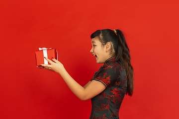 Image showing Happy Chinese New Year. Asian young girls\'s portrait isolated on red background