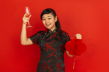 Image showing Happy Chinese New Year. Asian young girls\'s portrait isolated on red background