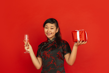 Image showing Happy Chinese New Year. Asian young girls\'s portrait isolated on red background