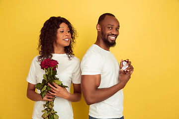 Image showing Valentine\'s day celebration, happy african-american couple isolated on yellow background