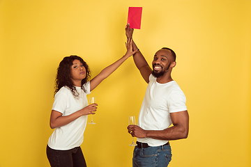 Image showing Valentine\'s day celebration, happy african-american couple isolated on yellow background