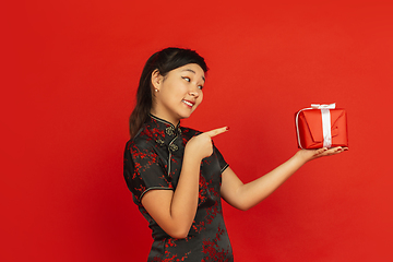 Image showing Happy Chinese New Year. Asian young girls\'s portrait isolated on red background