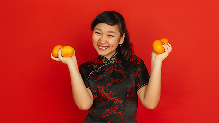 Image showing Happy Chinese New Year. Asian young girls\'s portrait isolated on red background