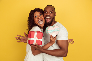 Image showing Valentine\'s day celebration, happy african-american couple isolated on yellow background