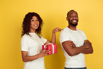 Image showing Valentine\'s day celebration, happy african-american couple isolated on yellow background