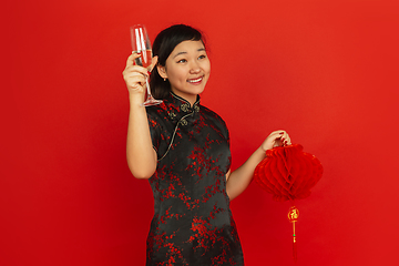 Image showing Happy Chinese New Year. Asian young girls\'s portrait isolated on red background