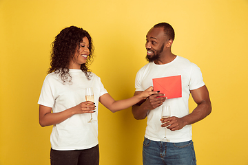 Image showing Valentine\'s day celebration, happy african-american couple isolated on yellow background