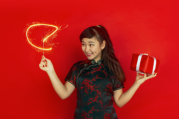 Image showing Happy Chinese New Year. Asian young girls\'s portrait isolated on red background