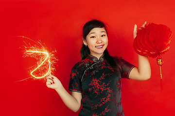 Image showing Happy Chinese New Year. Asian young girls\'s portrait isolated on red background