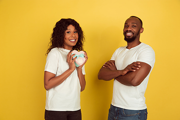 Image showing Valentine\'s day celebration, happy african-american couple isolated on yellow background