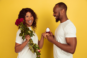 Image showing Valentine\'s day celebration, happy african-american couple isolated on yellow background