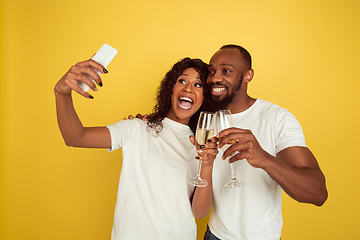 Image showing Valentine\'s day celebration, happy african-american couple isolated on yellow background