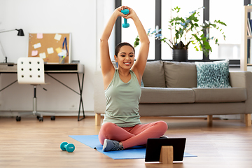 Image showing woman with tablet pc and dumbbell training at home