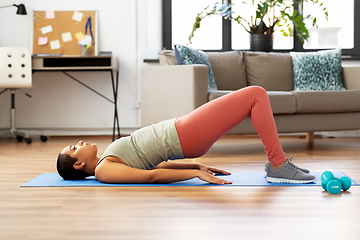 Image showing woman doing pelvic lift abdominal exercise at home