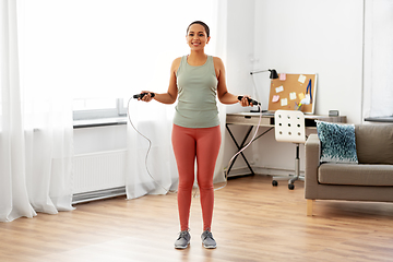 Image showing african woman exercising with jump rope at home