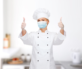 Image showing female chef in face mask showing thumbs up