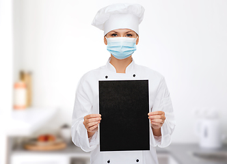 Image showing female chef in face mask with black menu tablet