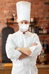 Image showing male chef in face mask at restaurant kitchen