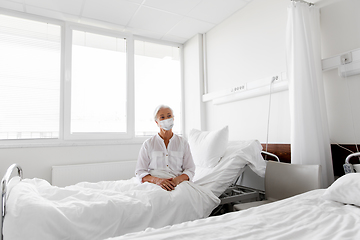 Image showing old woman patient in mask lying in bed at hospital