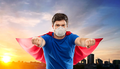 Image showing superhero man in respirator flying over city