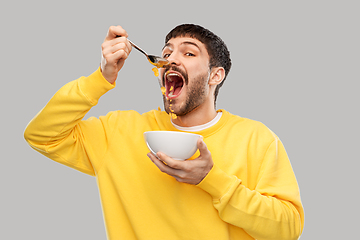 Image showing hungry young man eating cereals