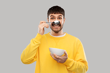 Image showing smiling young man with spoon and bowl having fun