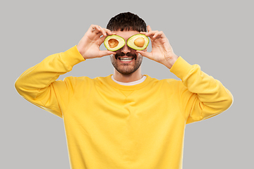 Image showing happy young man with avocado instead of eyes