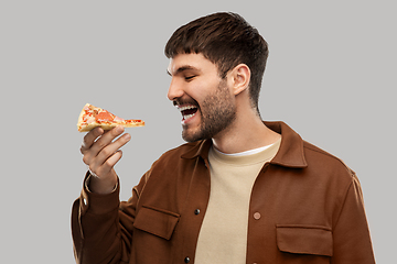 Image showing happy smiling young man eating pizza