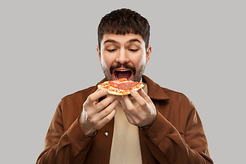 Image showing hungry young man eating pizza