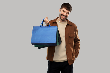 Image showing happy smiling young man with shopping bags