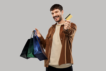 Image showing happy young man with shopping bags and credit card